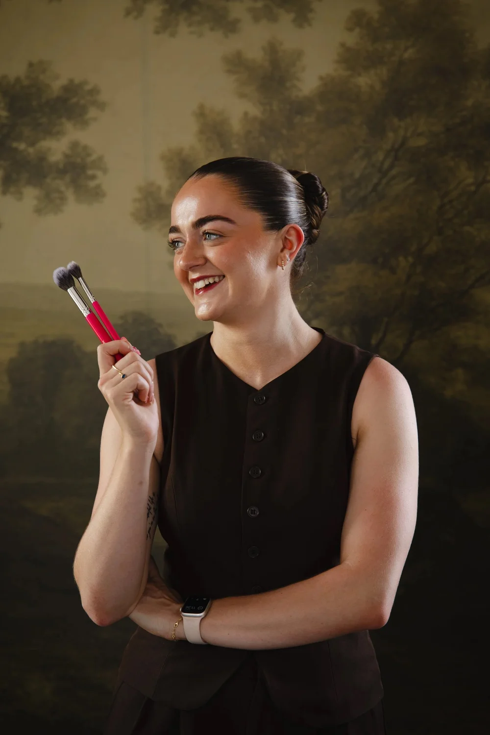 Beth Henry laughing with makeup brushes in her hand