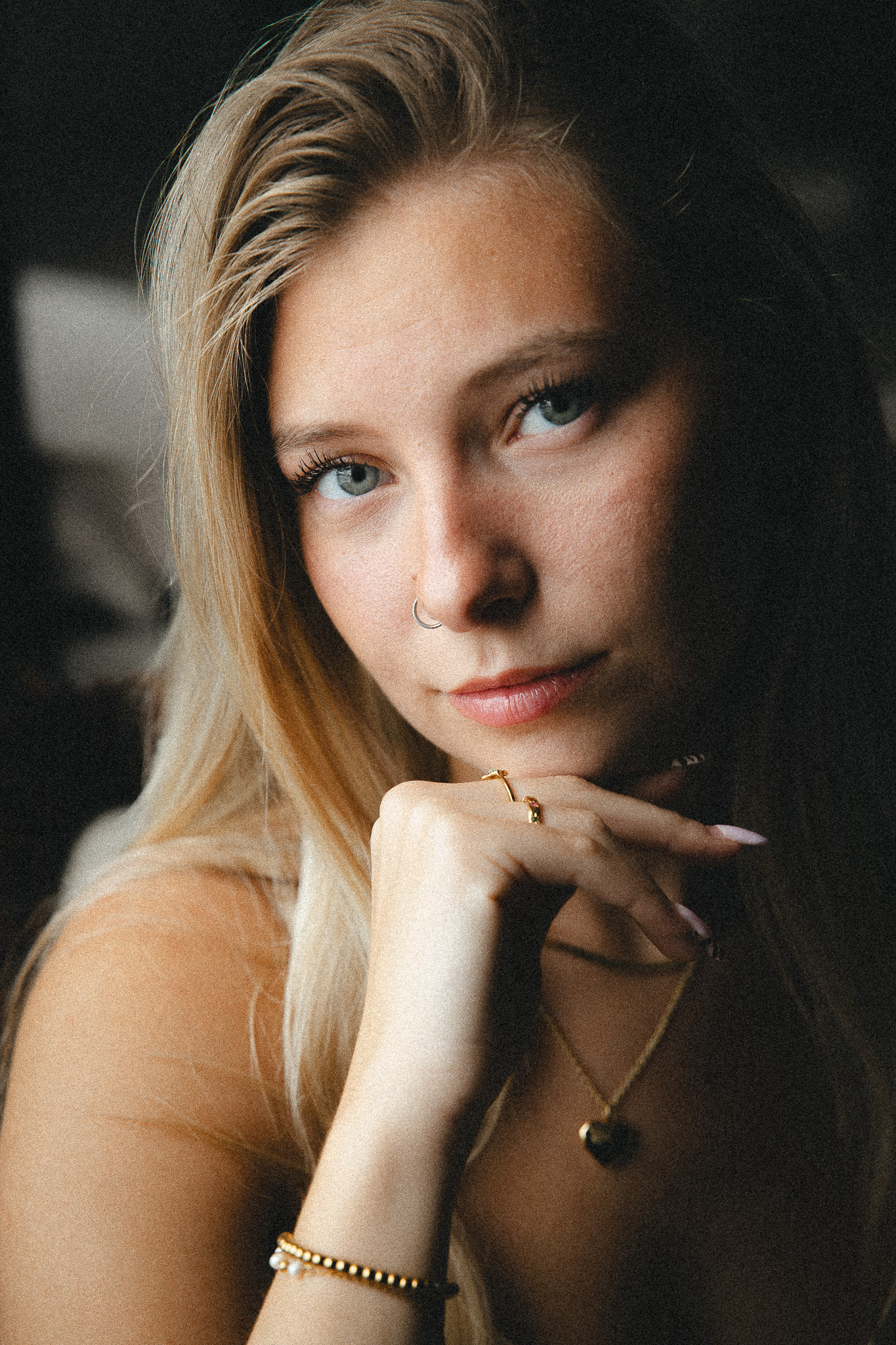 A softly lit client portrait, resting her chin on her hand