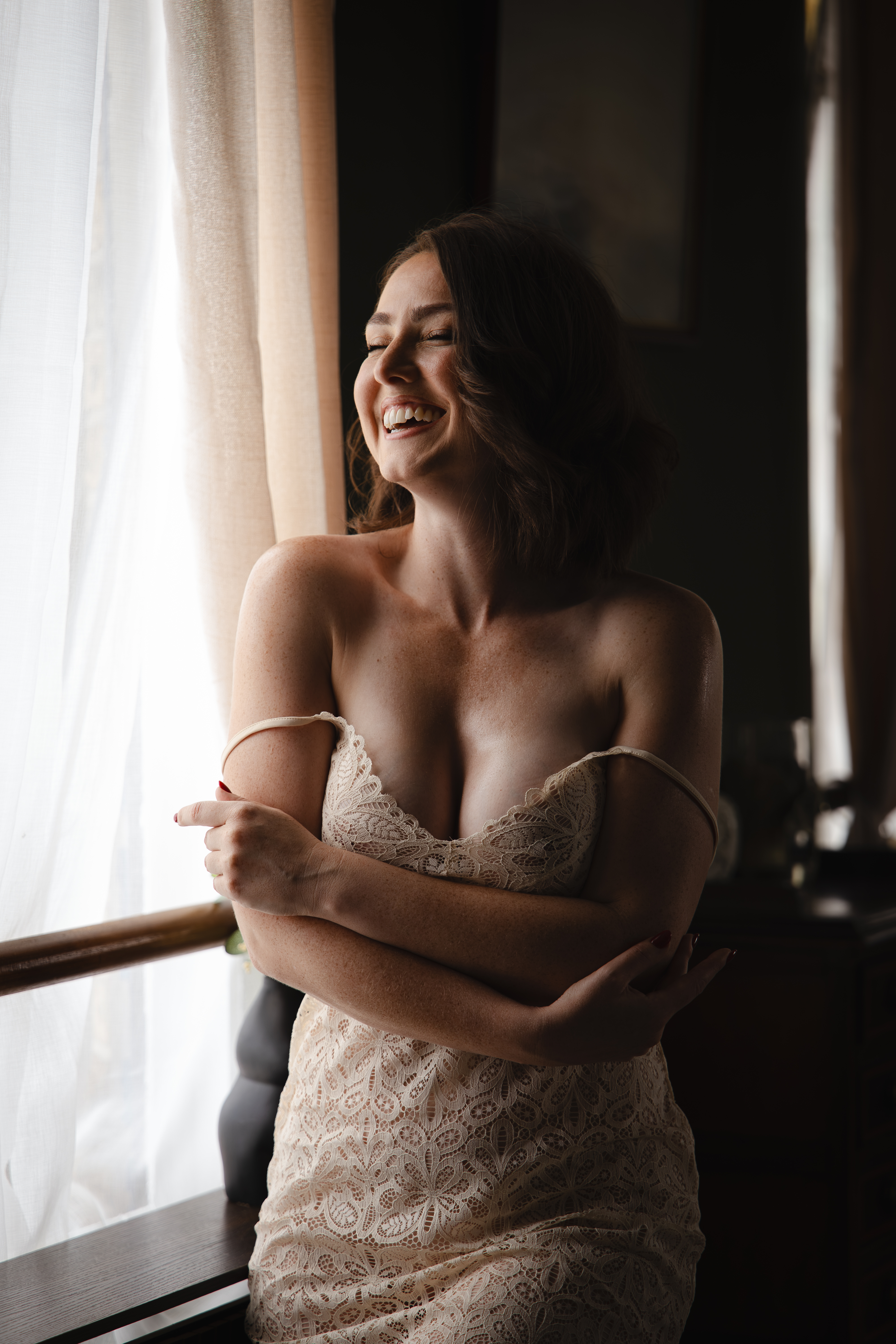 A client laughing in the soft light of the studio window